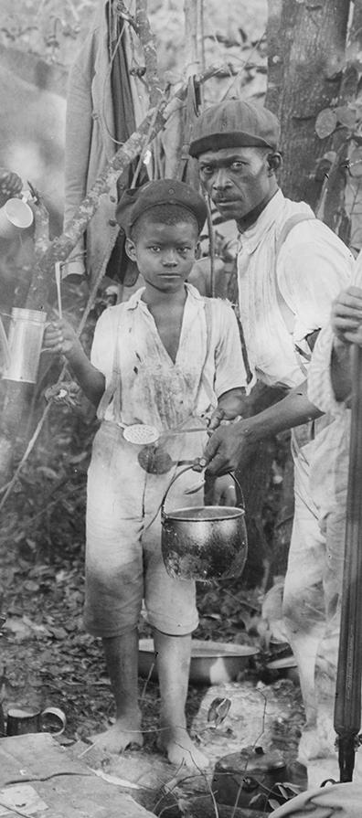 Um homem e um menino em um acampamento na mata fazendo café